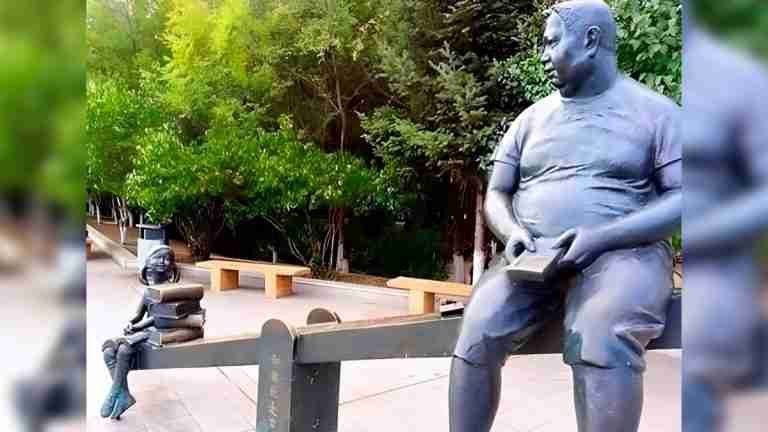 “Una imagen dice más que mil palabras”: niña con libros vence a niño con celular en una estatua 