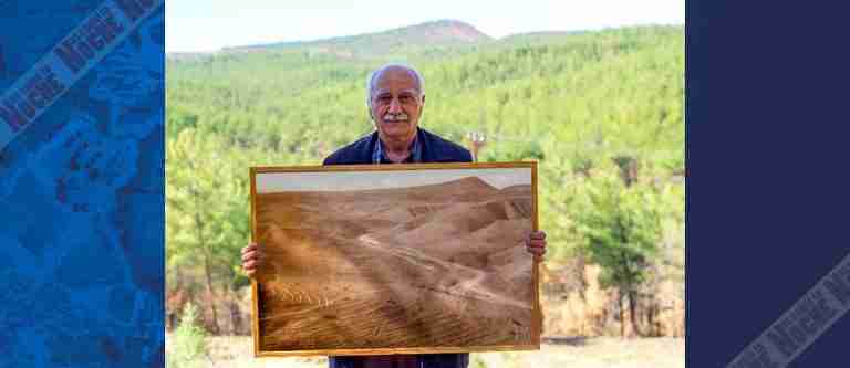 Hombre posa orgulloso con la foto del bosque que restauró